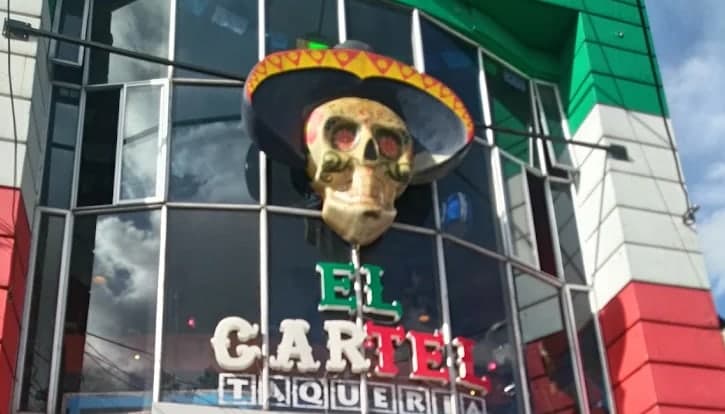 Fachada del local con una calavera gigante con sombrero sobre el rótulo El Cartel Taquería